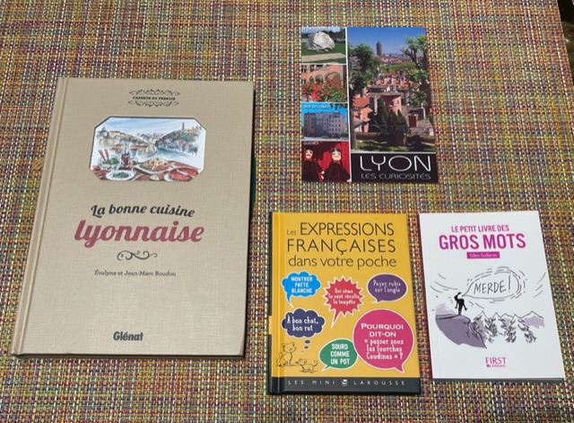Livre de recettes lyonnaises, deux petits livres avec des faits divers et une carte postale lyonnaise