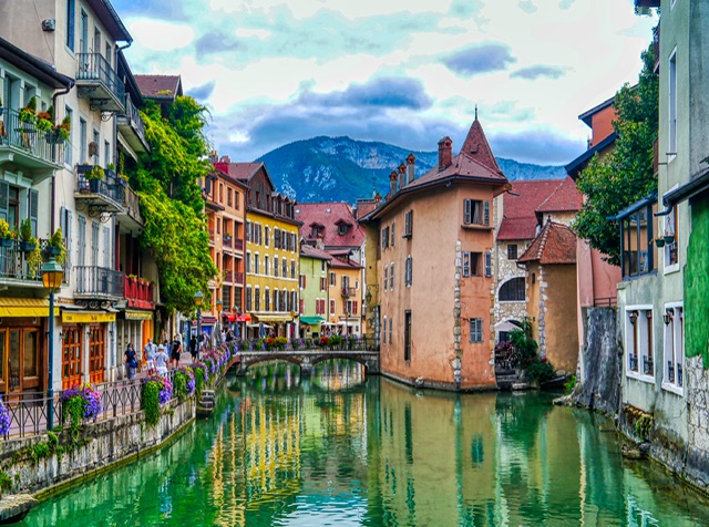 Le Palais de l'Île, sur un îlot au milieu du Thiou, avec des maisons aux couleurs vives, à Annecy en Haute-Savoie