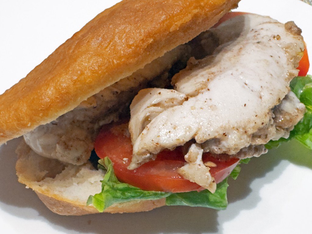 Le bokit, sandwich guadeloupéen avec du poulet, de la laitue et des tomates dans un petit pain frit à l'huile
