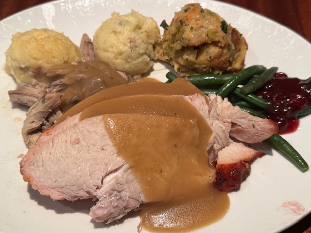 Dîner de Thanksgiving : la dinde avec sa sauce aux canneberges, de la purée de pommes de terre, des haricots verts, et ce qu'on appelle "stuffing", une farcie de pain et d'herbes qui est censée être cuite à l'intérieur de la dinde.