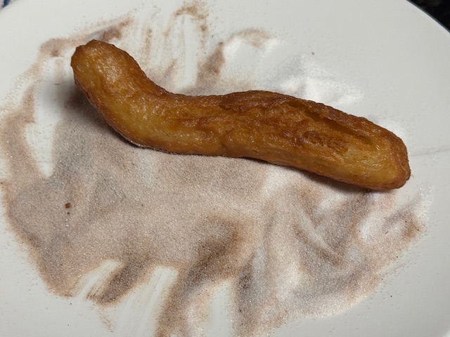 Churro dans le mélange sucre-cannelle