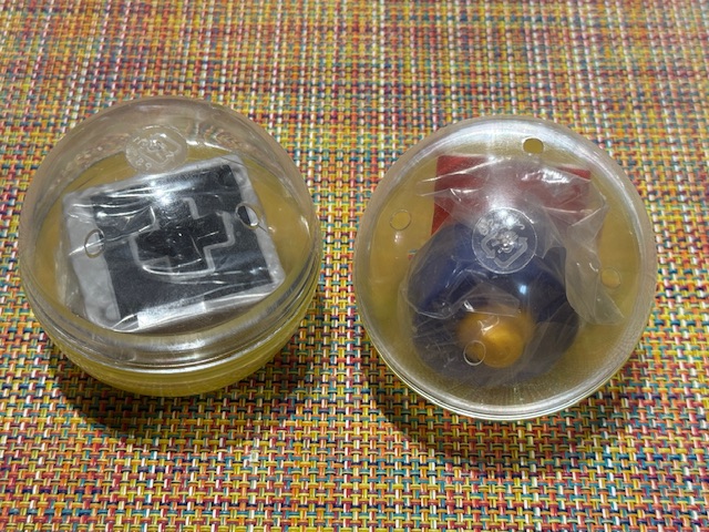 Photo de deux porte-clés manette dans leur emballage d'œuf en plastique.