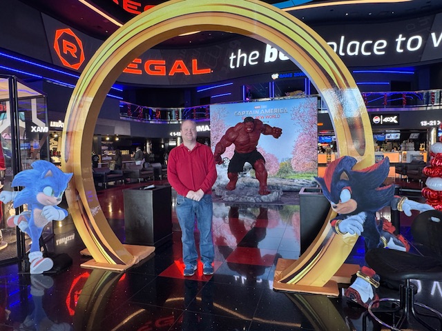 Photo de moi au centre d'un anneau du film en carton, qui sert en tant que porte au hall du ciné.