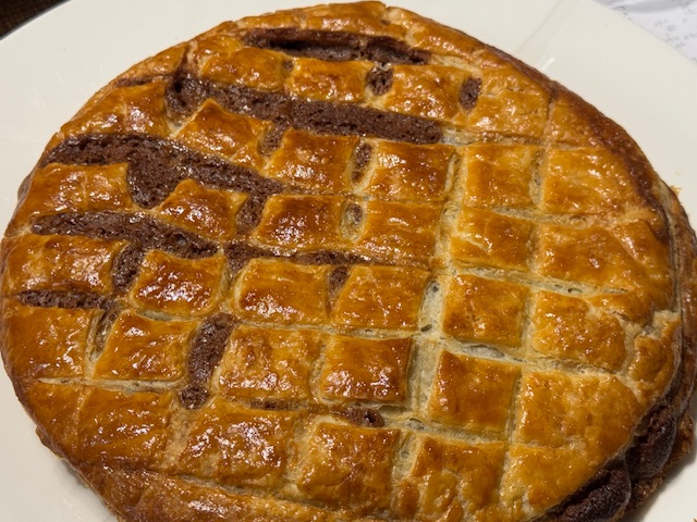 Galette des rois avec du chocolat qui a coulé à la surface après s'être échappé de l'intérieur. 