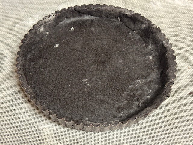 Moule garni de pâte -- il y a de nombreuses déchirures réparées visibles dans la photo