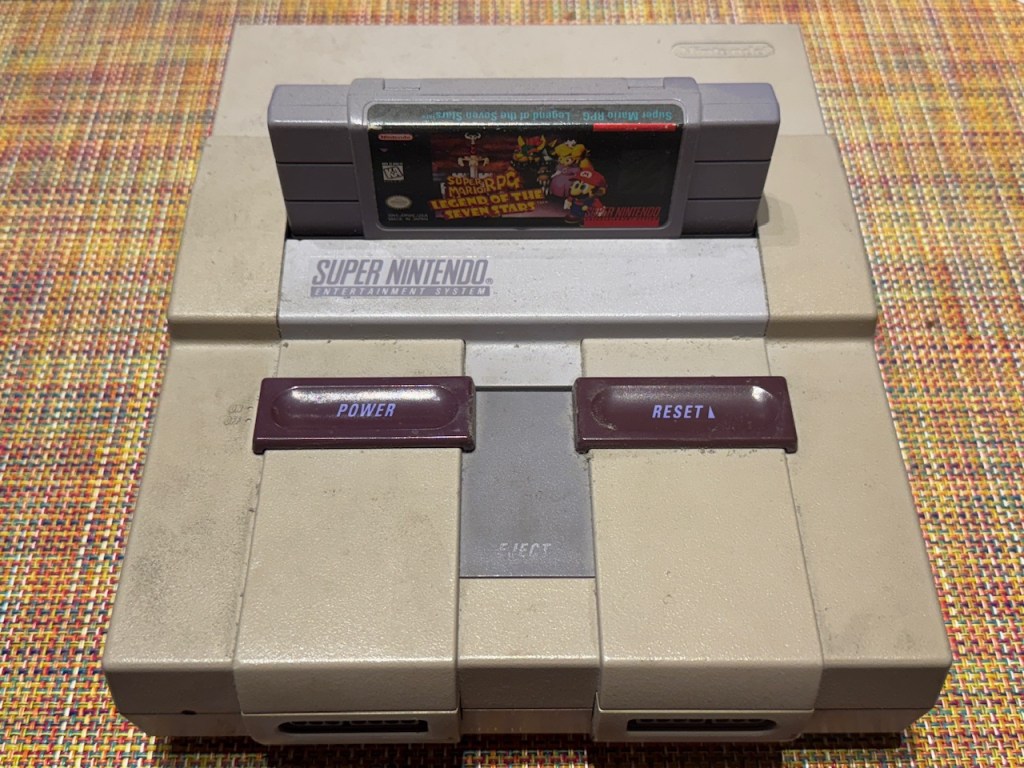 Super Nintendo avec une cartouche du jeu Super Mario RPG