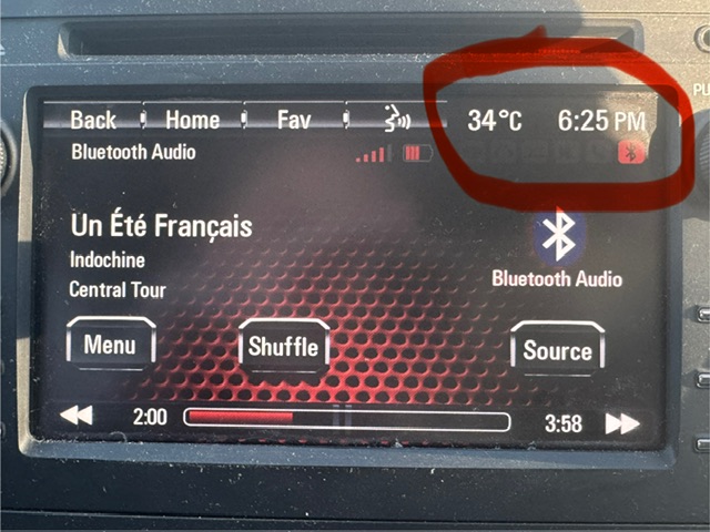 Photo de l'écran dans la voiture avec la température -- 34° C -- et l'heure, 18h25, soulignées en rouge. Ça montre aussi qu'Un été français d'Indochine joue à la radio.