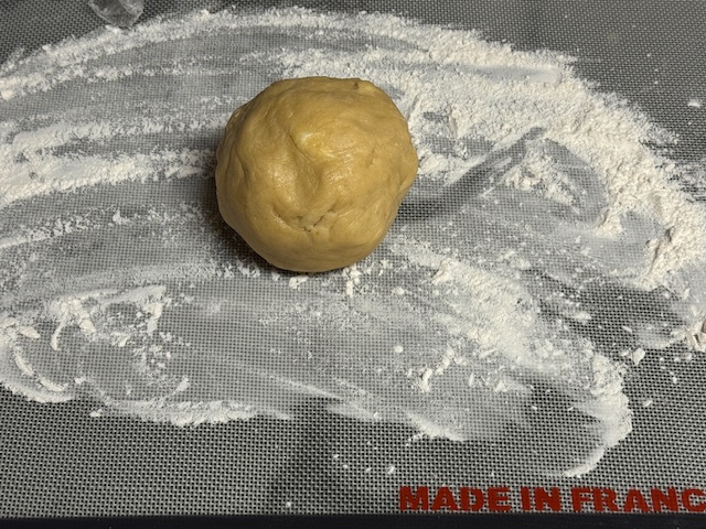 Boule de pâte posée sur un plan de travail fariné