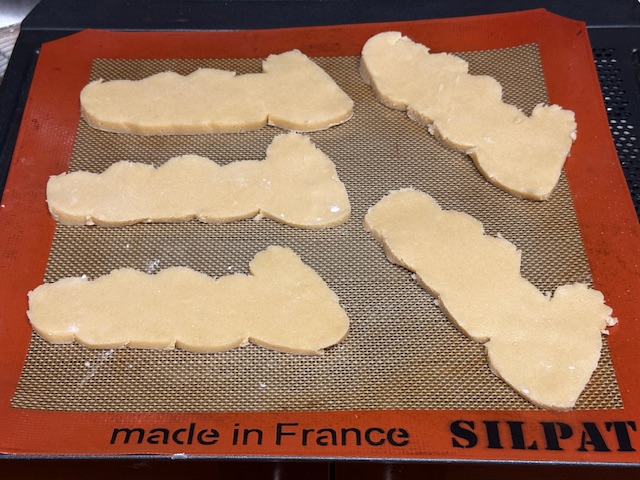 5 Wigglers en pâte sucrée sur un tapis en silicone avant de les enfourner