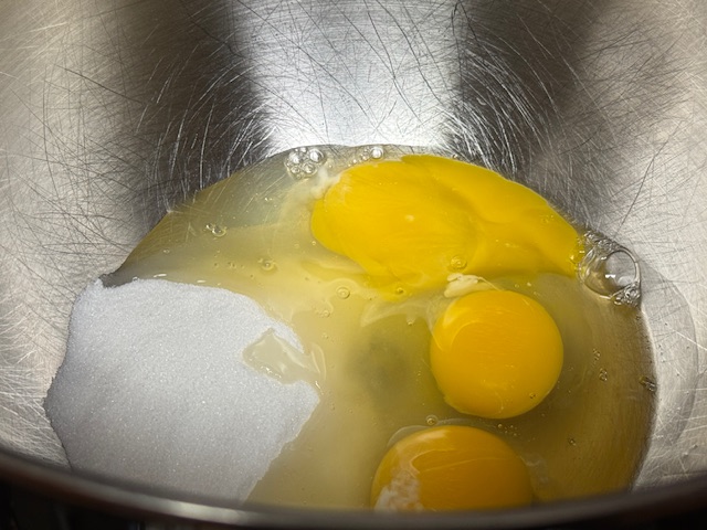 Œufs et sucre dans le bol d'un robot