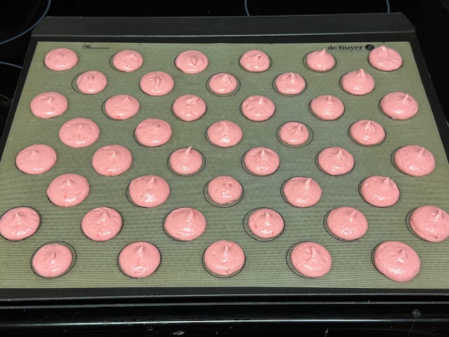 Premier lot de coques à la fraise après avoir tapé la plaque sur le four