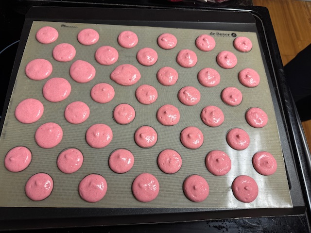 Deuxième lot de coques à la fraise après avoir tapé la plaque sur le four