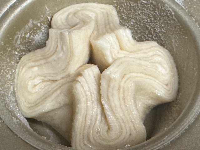 Petit kouign-amann dans un moule à muffins, prêt à enfourner