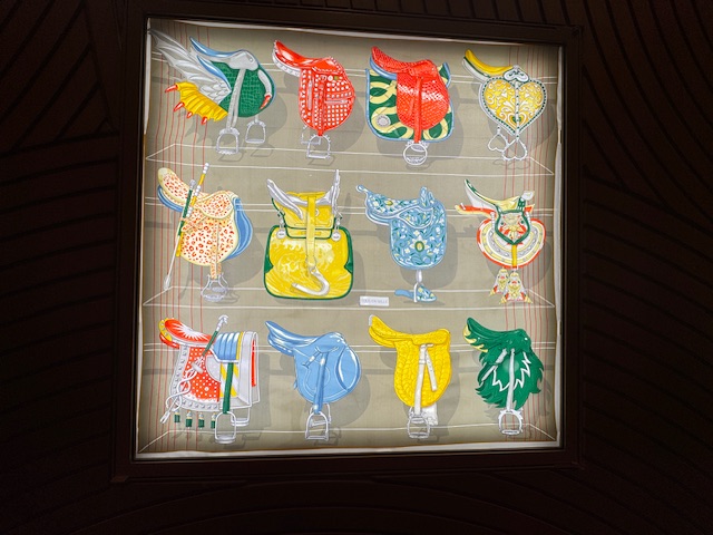 Dessins dans la vitrine de Hermès avec de nombreuses selles, en toutes les couleurs