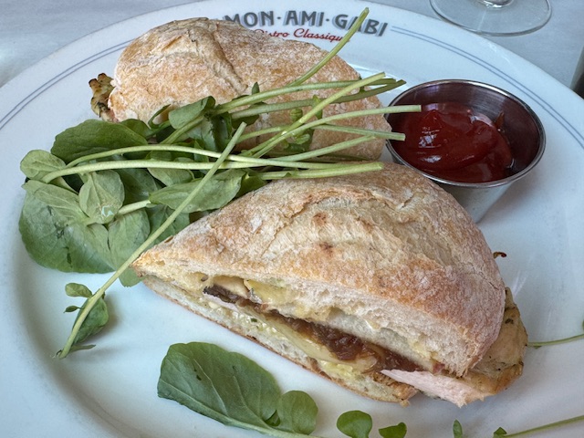 Sandwich au poulet et au brie, coupé en deux