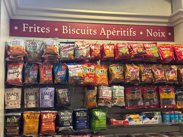 Dans l'épicerie, un panneau offre « Frites, biscuits apéritifs, noix ». Ça devrait dire « Chips, biscuits, fruits de coque »