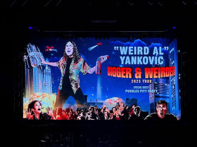 L'affiche dit « Weird Al : Plus grand et plus bizarre », bizarre étant la traduction de weird