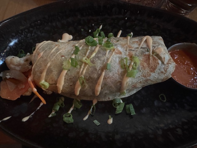 Burrito avec une sauce crémeuse un peu verte au-dessus