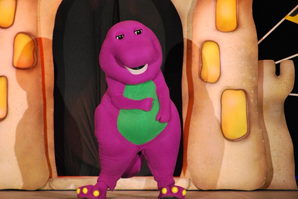 Photo de Barney le dinosaure, personnage de la télé américaine. Il est violet, avec un ventre vert.