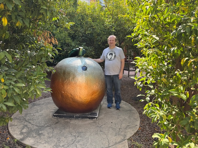 Moi avec une sculpture d'une orange qui fait environ 1,5 m.