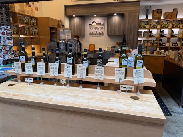 Une table avec une douzaine de bouteilles d'huile d'olive pour goûter