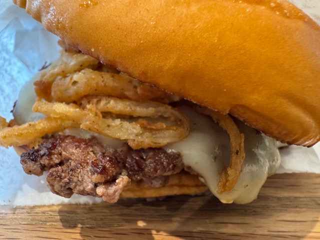 Mon burger, vu de trop proche -- les oignons frits et le pain sont les trucs les plus visibles