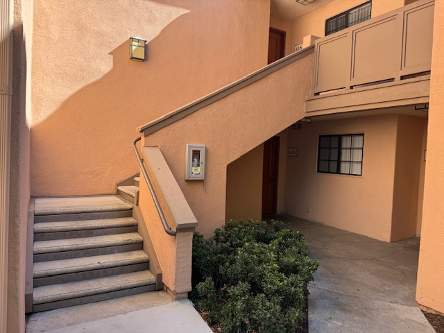 Photo de l'escalier qui mène au nouveau appartement. Il y a 5 marches, puis un palier, puis une dizaine de marches après un virage de 90 degrés pour atteindre le premier étage.