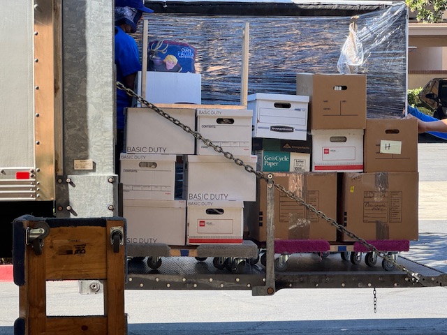 Photo d'une douzaine de cartons en train de descendre d'un camion
