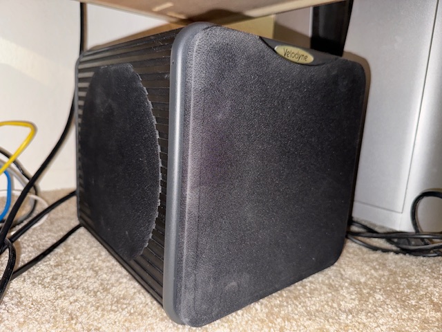 C'est un caisson de basse Velodyne, dit MicroVee, placé sous mon bureau. Un cube de 30 cm le côté, c'est pourtant équipé d'un amplificateur de mille watts. Cependant, il est réglé sur un volume très bas, afin de ne pas trop déranger le voisin du dessous.