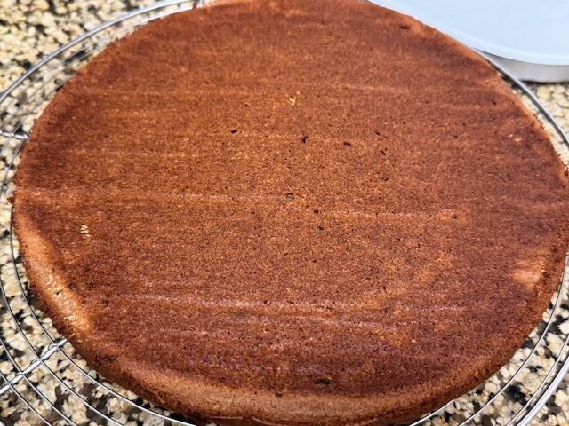 Deuxième gâteau sur une grille. On voit que le fond, ce qui sera le haut pour le montage, est plat avec moins de dégâts que le premier.