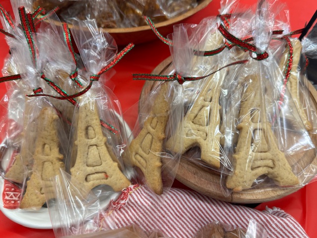 Deux assiettes de biscuits en forme de la Tour Eiffel, emballés individuellement et attachés avec un ruban rouge et vert.