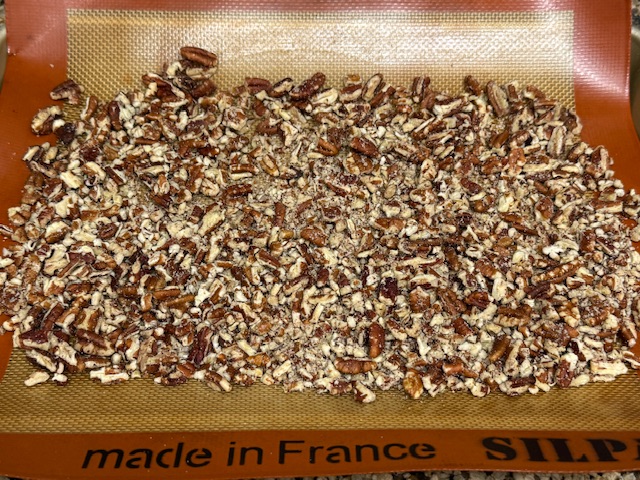 Noix de pécans étalees sur la plaque de cuisson, toujours crues