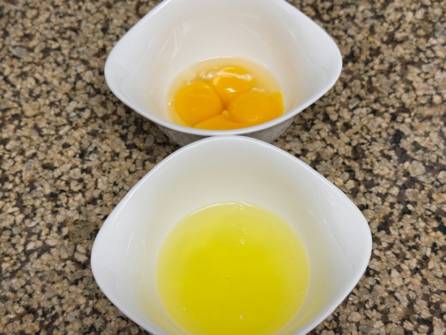 Deux petits bols avec les jaunes et les blancs.