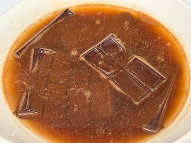 Chocolat noir et eau après avoir sorti du micro-ondes. Le chocolat retient sa structure et flotte dans l'eau.