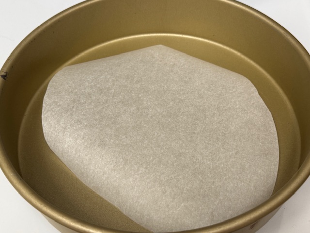 Moule chemisé de papier de cuisson ; le fond n'est pas complètement recouvert