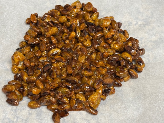 Les pistaches caramélisées sur une feuille de papier de cuisson. Pas brûlées du tout !