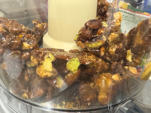 Brisures de praliné dans le bol du robot avant de mixer