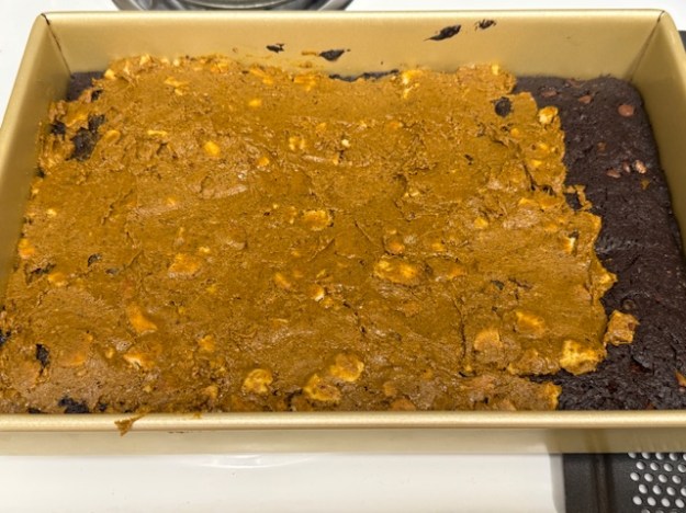 Praliné étalé sur les brownies. Il y a une bande sans praliné à droite, car pas assez pour étaler sur tout.