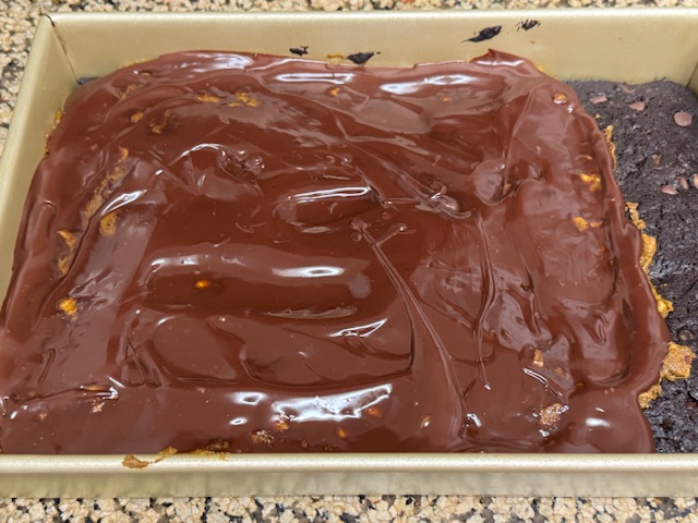 Ganache étalée uniquement sur le praliné -- la bande de brownie sans praliné n'a pas reçu de ganache.
