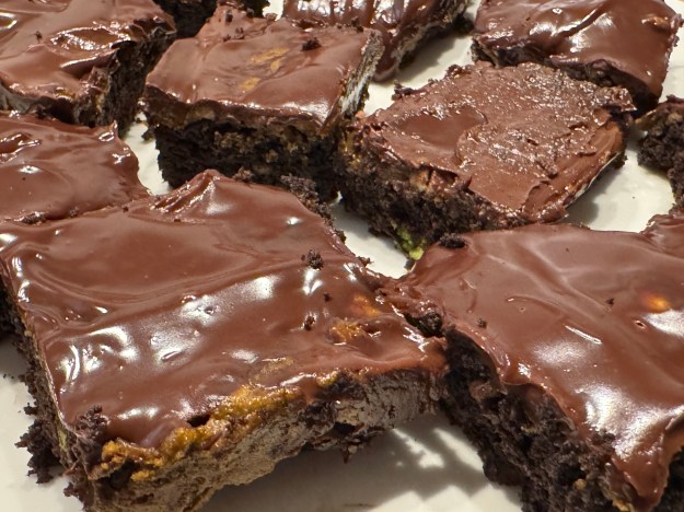 Brownies coupés en gros plan. La ganache est solide, mais la surface est rugueuse. La ganache brille car c'était préparé correcetement, homogène et sans feu vif.