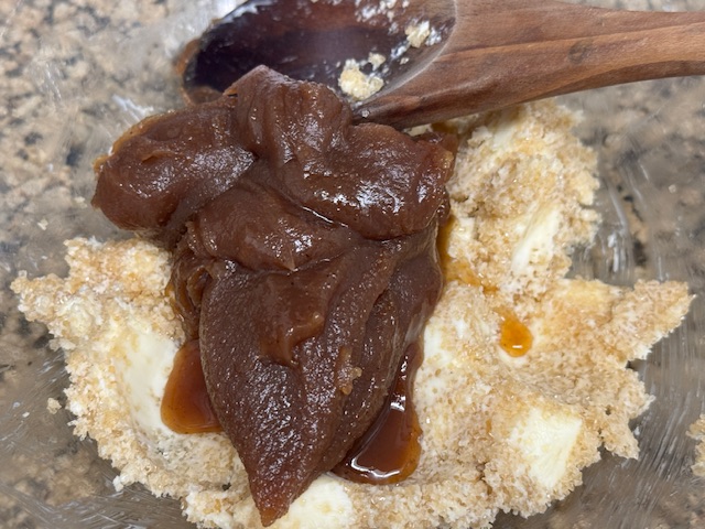 Crème de marrons sur le tas de beurre et cassonade, avec une cuillère en bois en arrière plan.