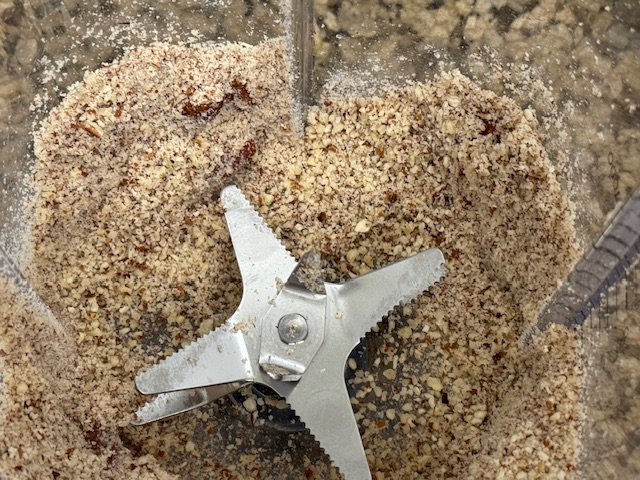 Fond du bol de mixeur -- il y a de la poudre de noix de pécan, ainsi que quelques brisures de pécan.