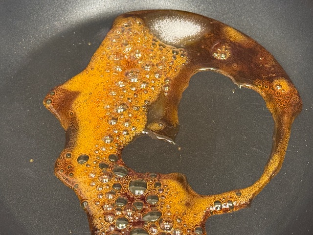 Caramel légèrement bouillant, il ne reste qu'un petit tas de sucre, et il y a des bulles partout où est le caramel.