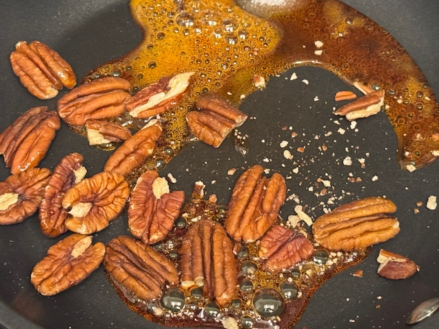 Noix de pêcan sur le caramel bouillant