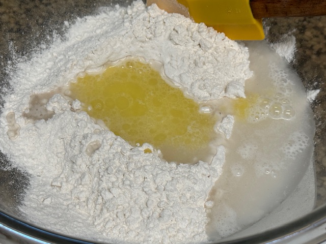 Saladier plein de farine. Il y a un puits au centre avec l'eau et le beurre fondu.
