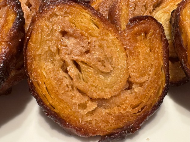 Oreja bien dorée en gros-plan. Les bords d'autres orejas sont visibles aux deux côtes, ainsi qu'en arrière, car c'est une photo très proche de l'assiette