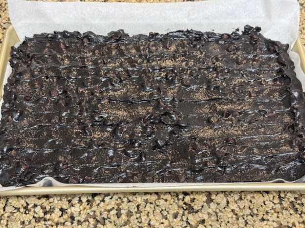 Pâte étalée sur la plaque de cuisson ; avec les pépites, la surface est très rugueuse