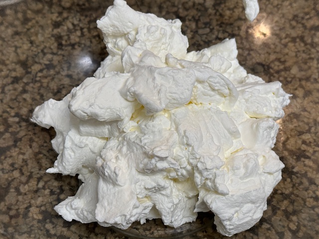 Crème fouettée dans le saladier, qui est translucide. On voit le comptoir.