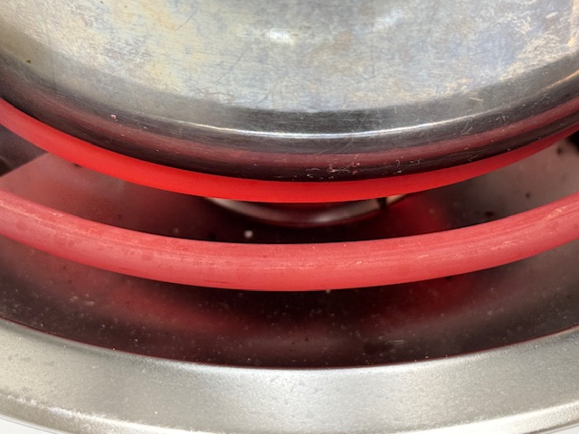 Serpentin chauffant de la cuisinière en gros plan. C'est très rouge ; ça montre que le chauffage est au maximum