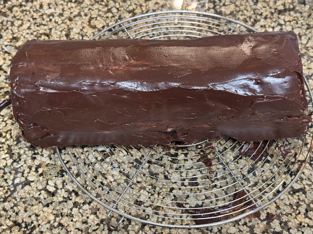 Bûche posée sur une grille, avec la surface beaucoup plus lisse qu'avant